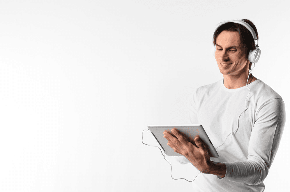Smiling man wearing headphones looking at a tablet