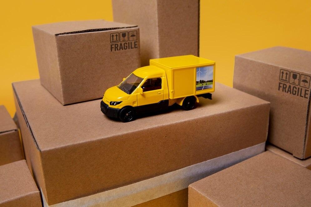 Toy delivery truck surrounded by cardboard parcels marked fragile