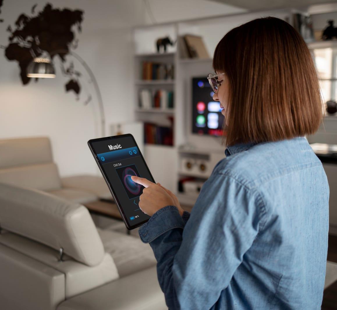 Woman controlling her smart home system from a tablet