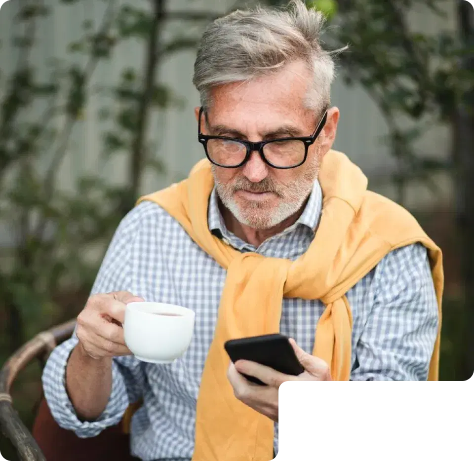 Man with a cup of coffee checking his phone